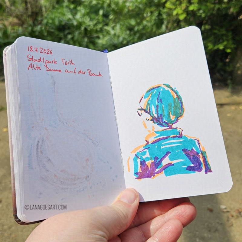 Sketchbook in a hand with green behind it. The sketch shows a lady with short hair in orange, turquoise and purple.